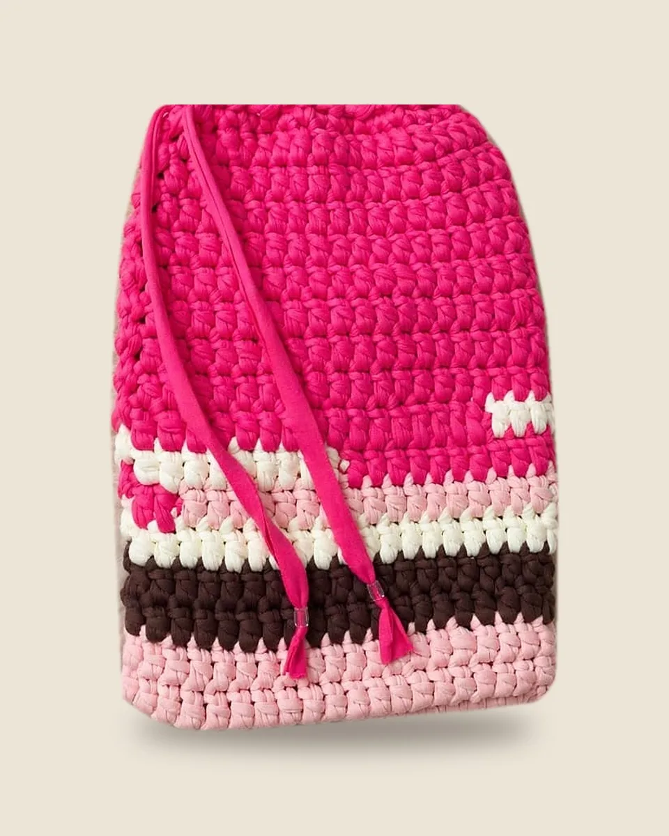 Pochette pour tablette en crochet à cordon de serrage, rose fuchsia rayée de crème, rose pâle et chocolat, sur fond uni