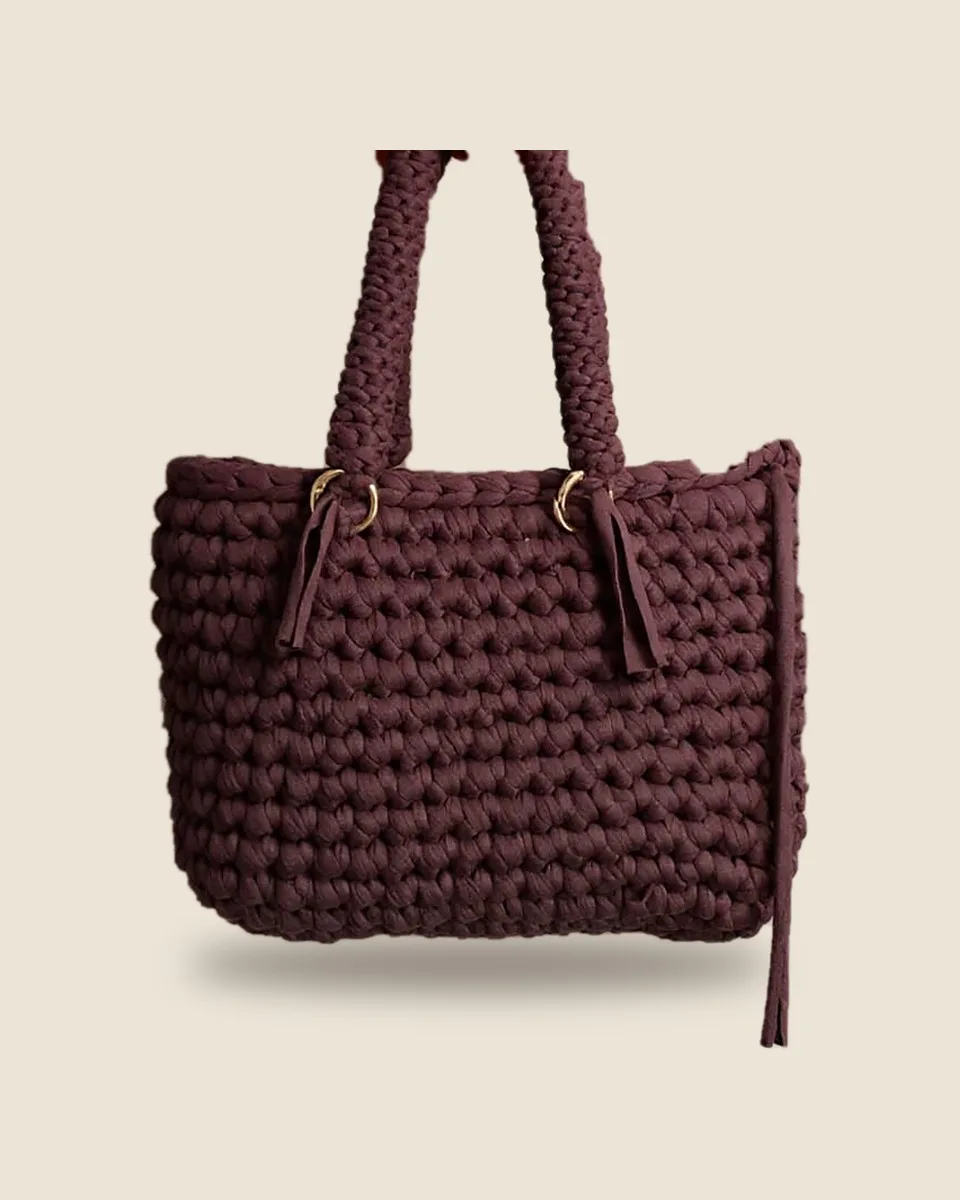 Sac à main en crochet prune, anses tressées et anneaux dorés, sur fond uni
