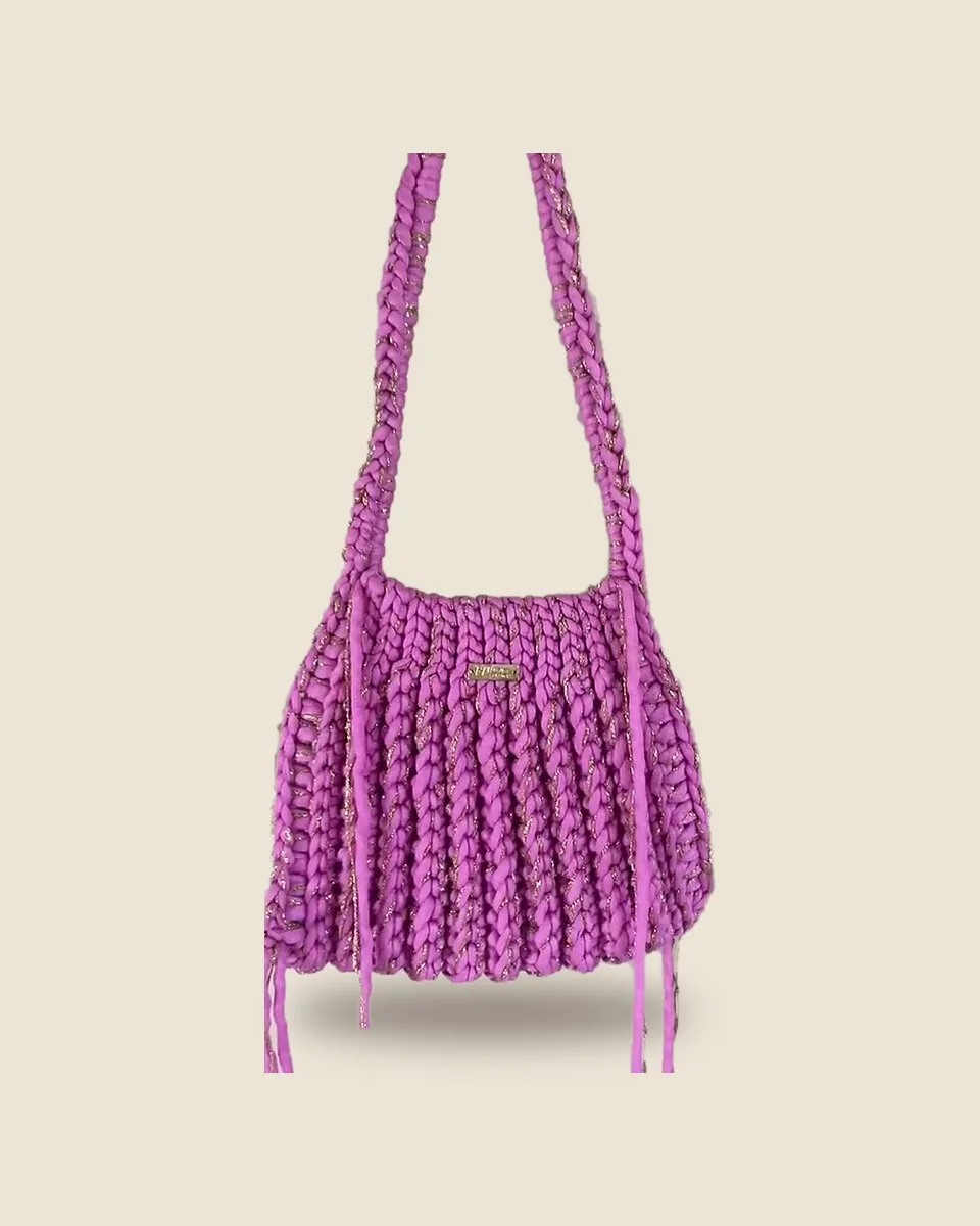Sac bandoulière en crochet rose fuchsia à côtes verticales et fil doré, sur fond uni